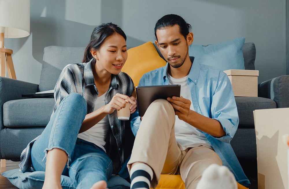 Un jeune couple faisant des recherches sur les CGM implantables à partir d’une tablette.