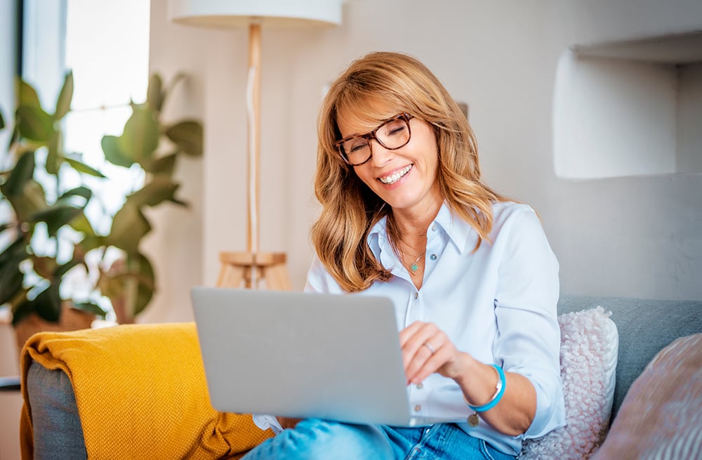 Une femme utilisant son ordinateur portable pour déterminer si sa couverture d’assurance s’applique aux systèmes de surveillance du glucose en continu.