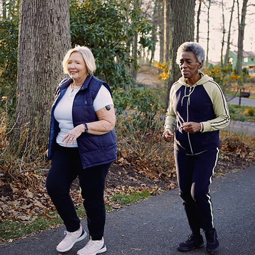 Deux femmes dotées de dispositifs de CGM Eversense se baladant.