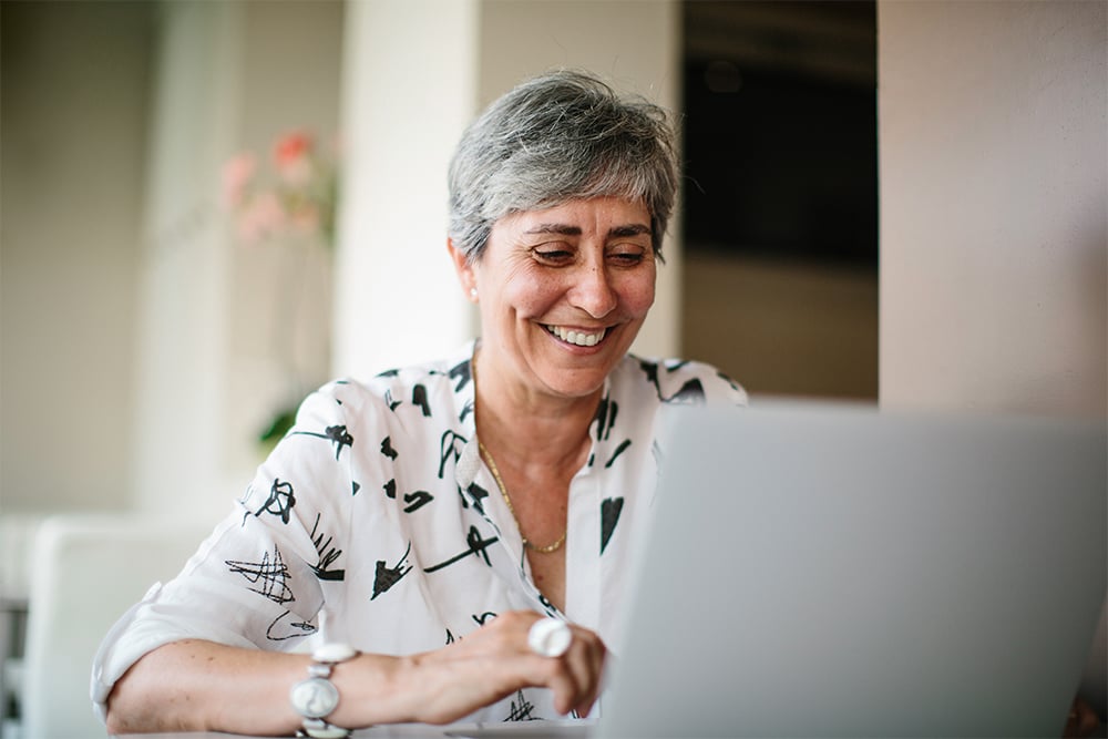 Donna che utilizza il computer portatile per effettuare ricerche sull’applicazione CGM per il monitoraggio wireless del glucosio.